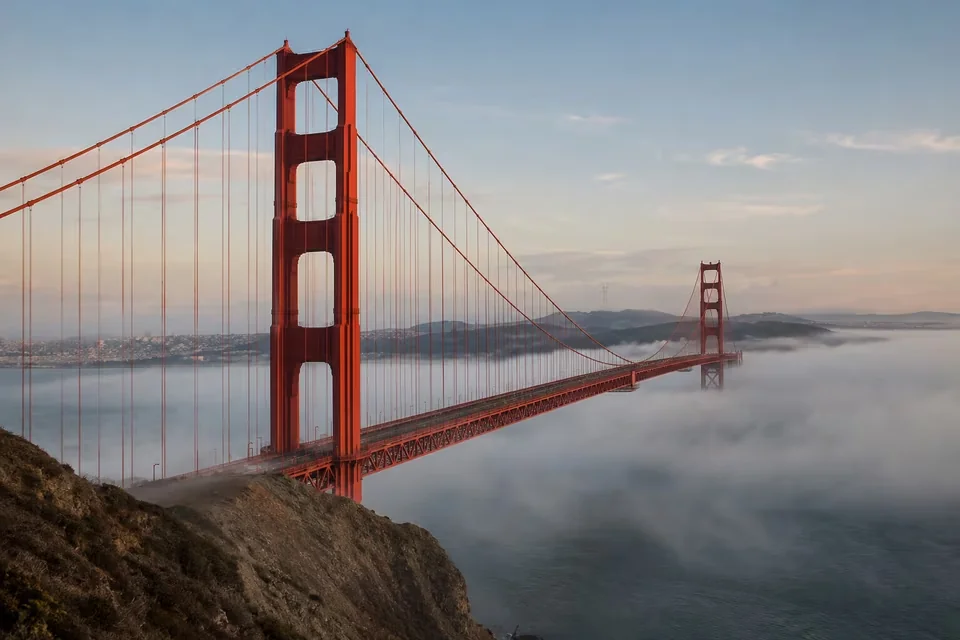 The Golden Gate Bridge, its red towers rising above the fog