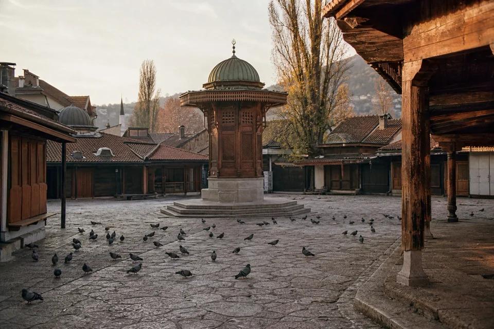Pigeons around the wooden fountain in the old bazaar square in Bosnia and Herzegovina