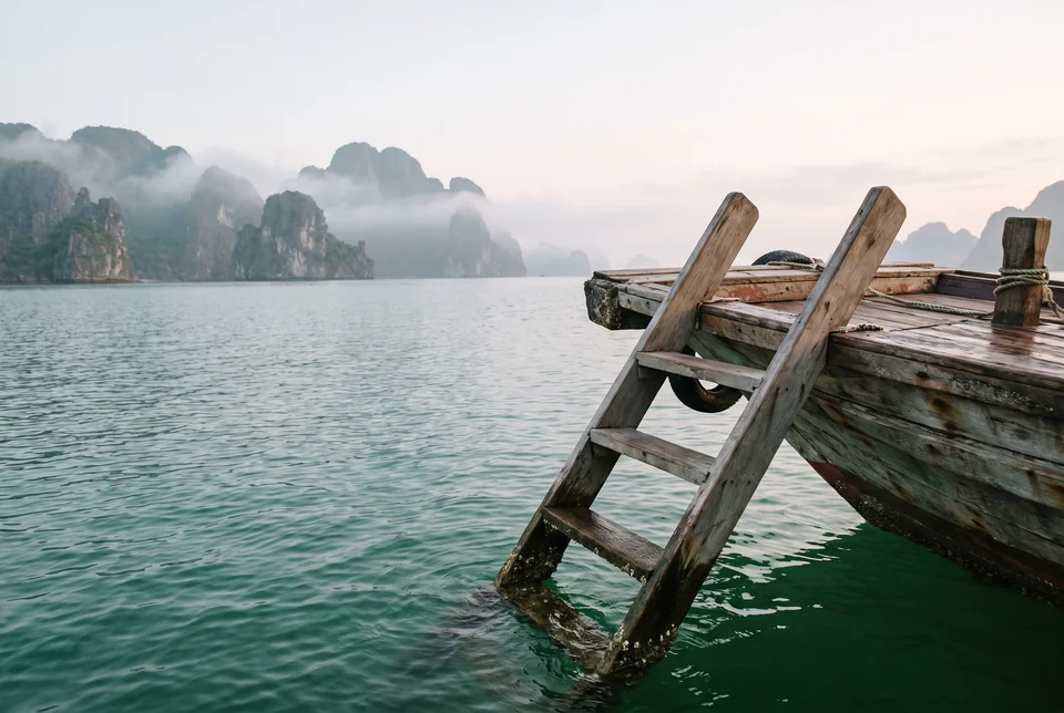 Emerald water and a wooden boat ladder in the morning mist of Ha Long Bay, visualization