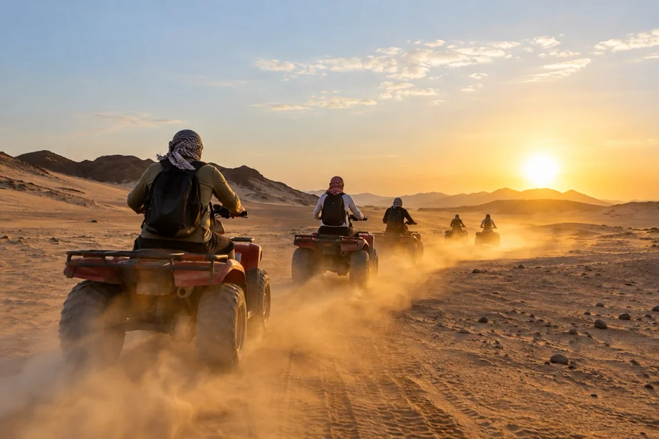 ATV safari riders kicking up dust in the Hurghada desert, seen from behind