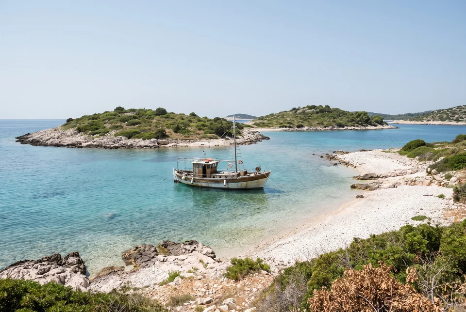 Turquoise bay, islets and an anchored boat at Ksamil on the Ionian Sea, visualization