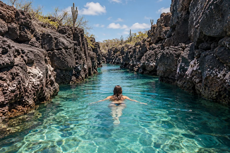Swimmer in a clear channel between volcanic rock walls; visualisation