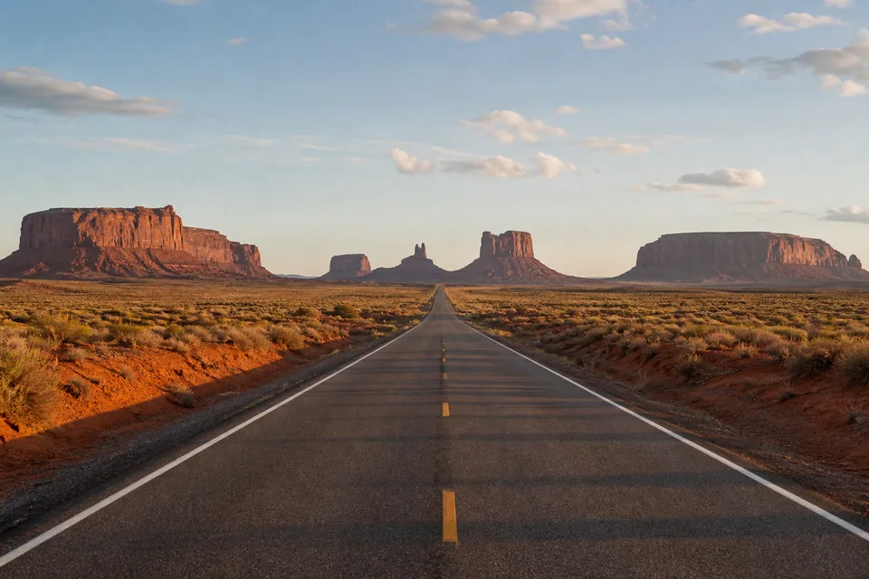 Route 66 running toward the horizon in Monument Valley