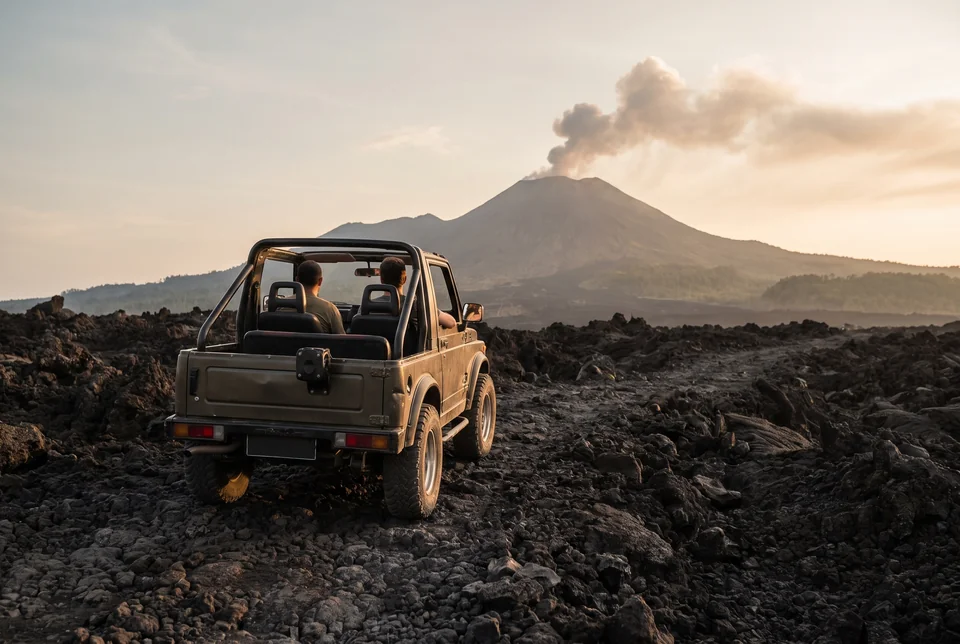 Open jeep on a black lava field below Mount Merapi, visualization
