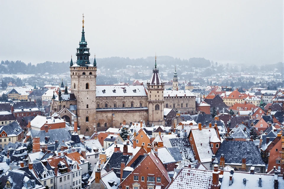 Stone towers rising over the red-roofed old town of Estonia under snow
