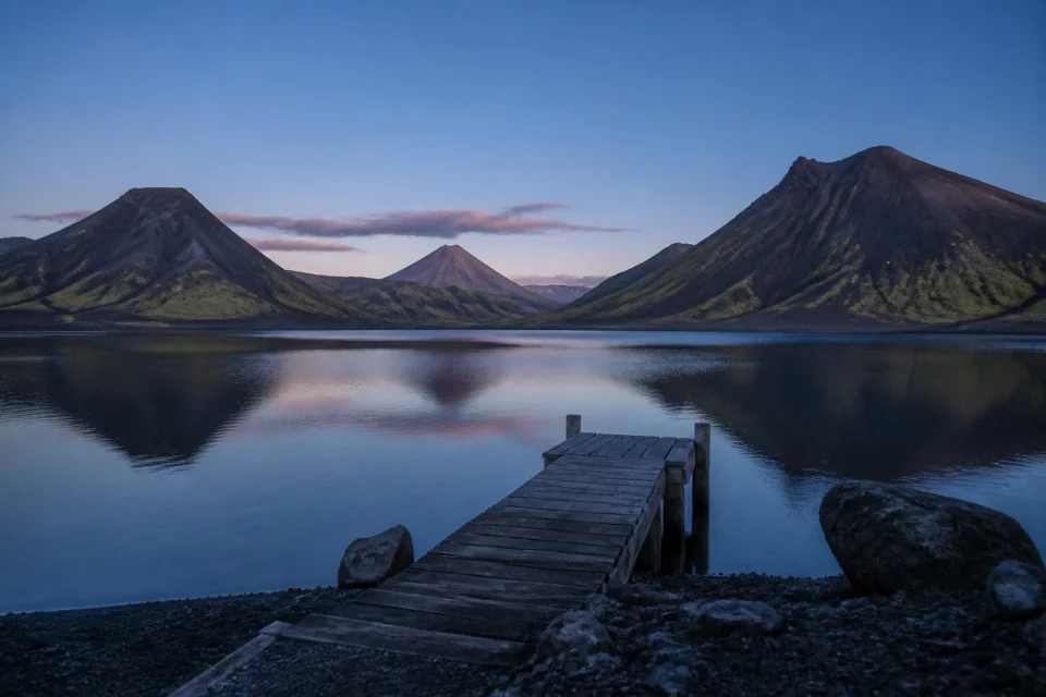 A small wooden jetty on a mountain lake ringed by volcanic hills in Guatemala