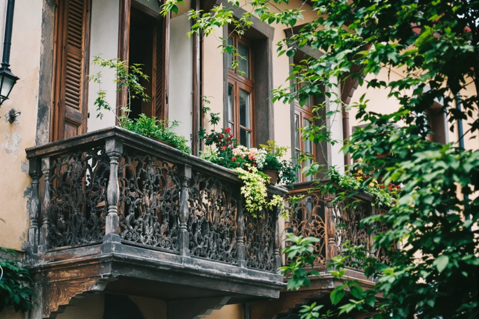 A balcony with carved wooden railings standing out on an old town street in Georgia