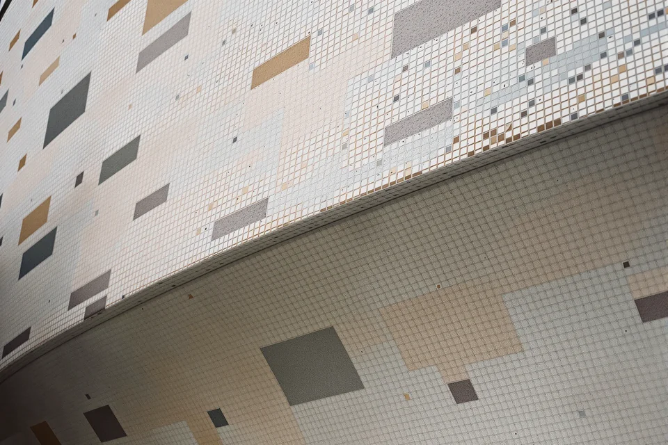 Colourful mosaic tile patterns seen close up on a curving facade in Spain