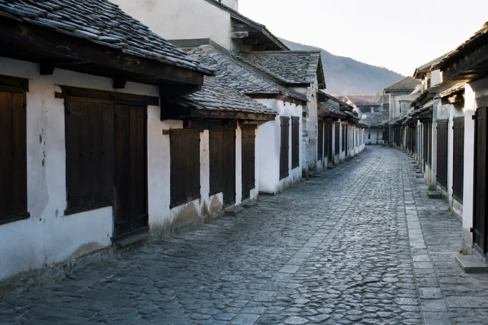 A long cobbled bazaar street lined with low whitewashed shops in Kosovo