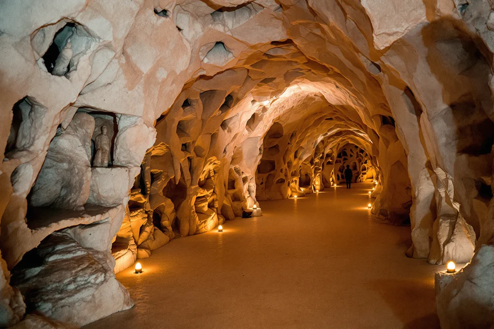 Lamps casting dim light in a carved stone chamber of a salt mine in Poland