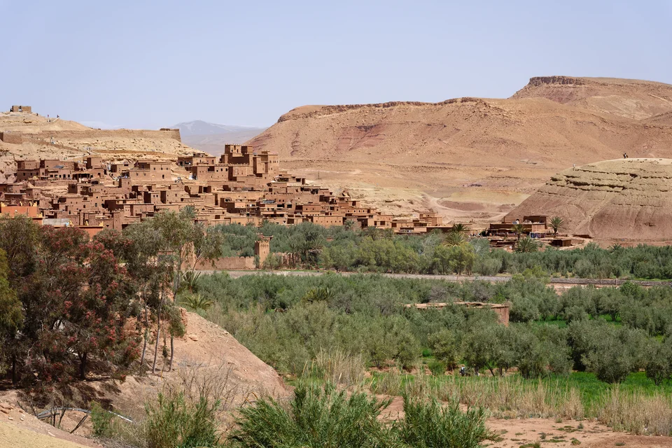 The green valley, the mud-brick village and desert hills beyond at Ait Benhaddou