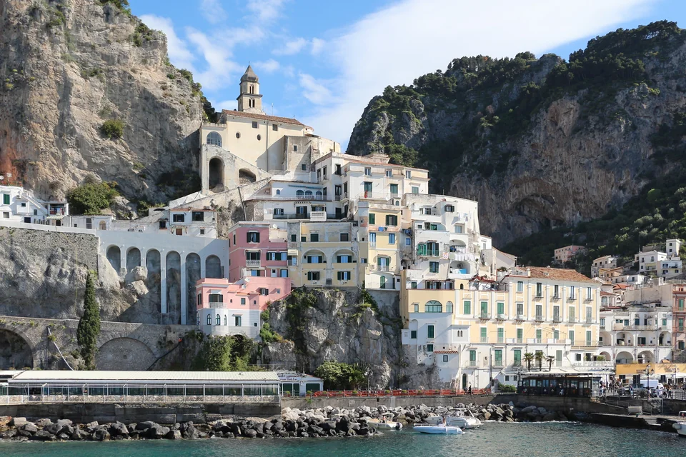 Colourful houses and the cathedral bell tower below steep cliffs in Amalfi