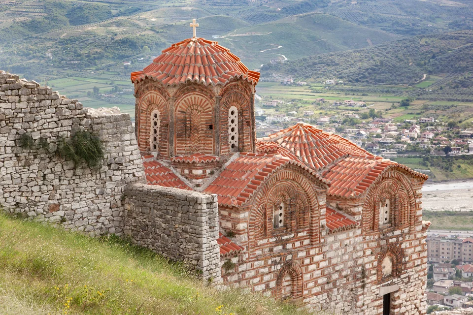 A red-brick Byzantine church in Berat Castle with the Osum valley below