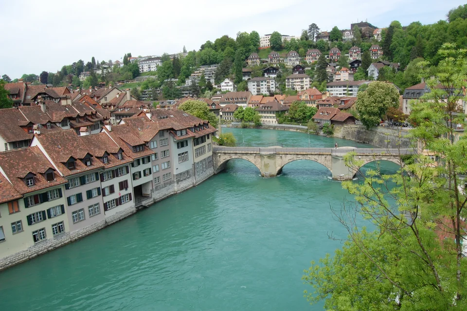 The Aare River, a stone bridge and the tile-roofed old town houses of Bern