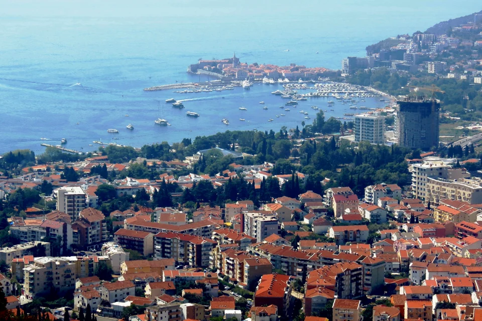 Red rooftops, the walled old town and the marina of Budva seen from above