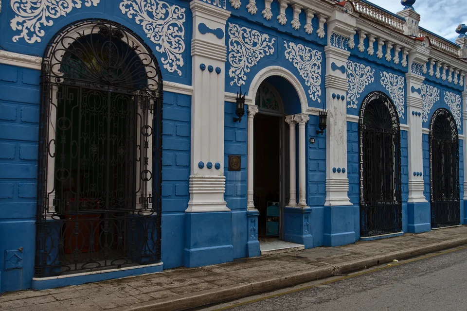 A blue-fronted historic colonial building with white ornament in Camagüey