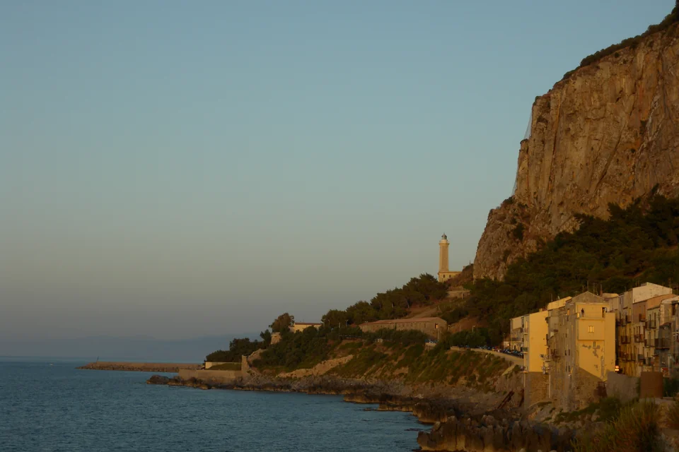 The sheer headland, the lighthouse and old waterfront houses of Cefalù