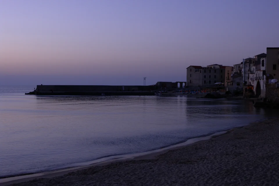 The beach, the harbour and the old town's waterfront houses at dusk, Cefalù