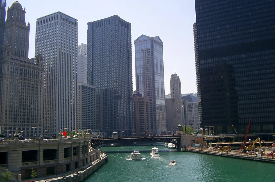 Skyscrapers rising along the Chicago River with boats on the water