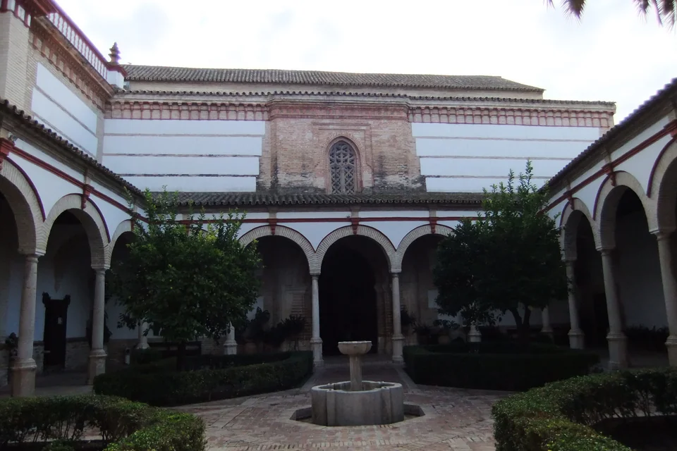 A cloister courtyard ringed by arcades with a fountain at its centre in Écija