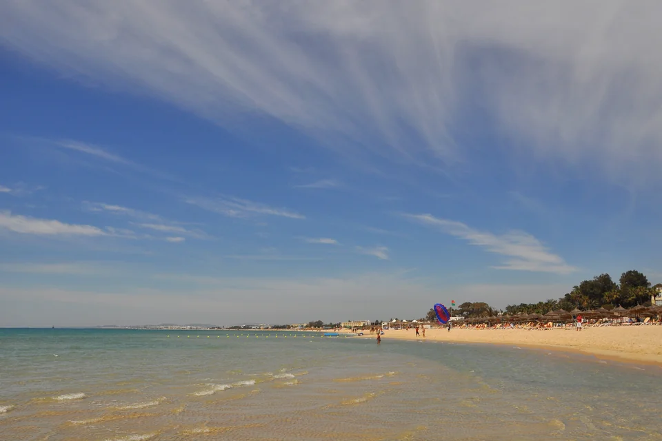 Shallow turquoise water and a long sandy beach in Hammamet