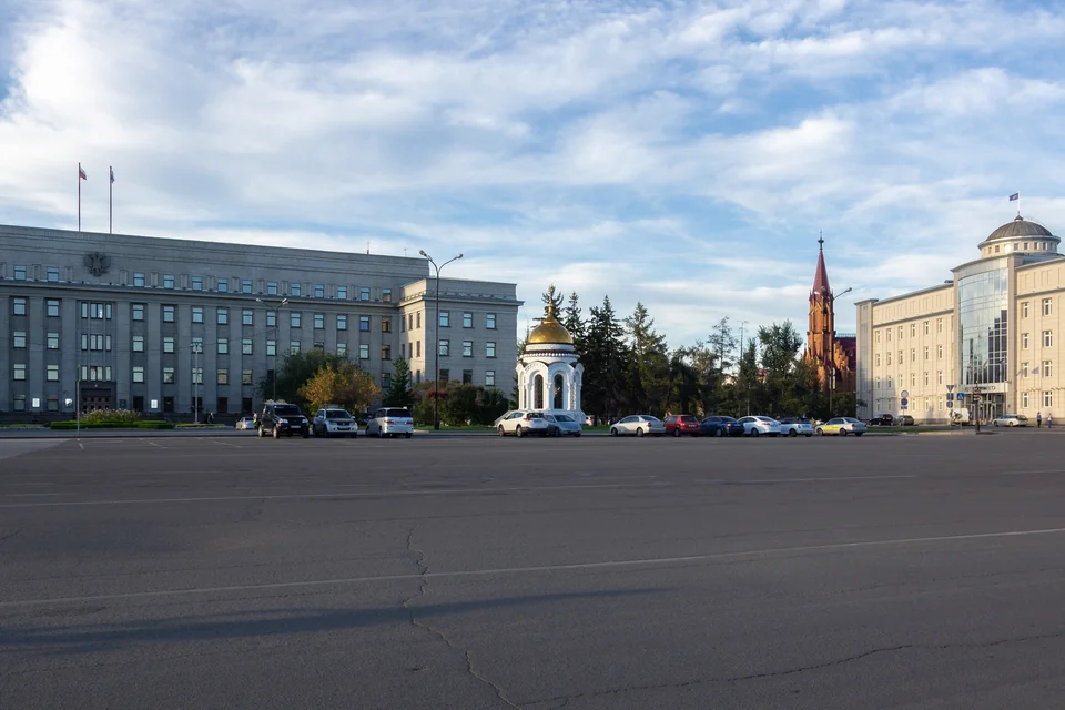 A wide square with historic buildings and a red-spired church in Irkutsk