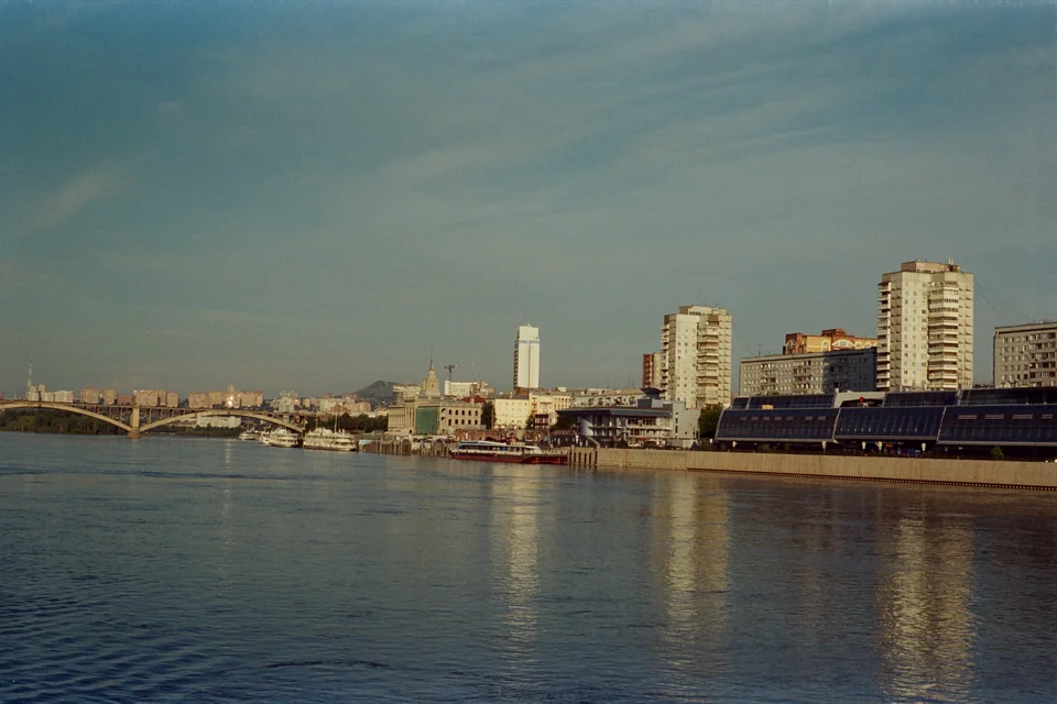 The Yenisei River embankment, an arched bridge and city buildings in Krasnoyarsk