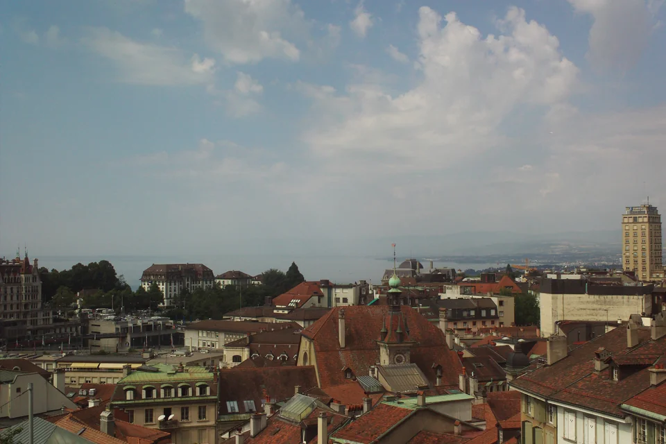 The tile-roofed old town of Lausanne with the lake in the distance