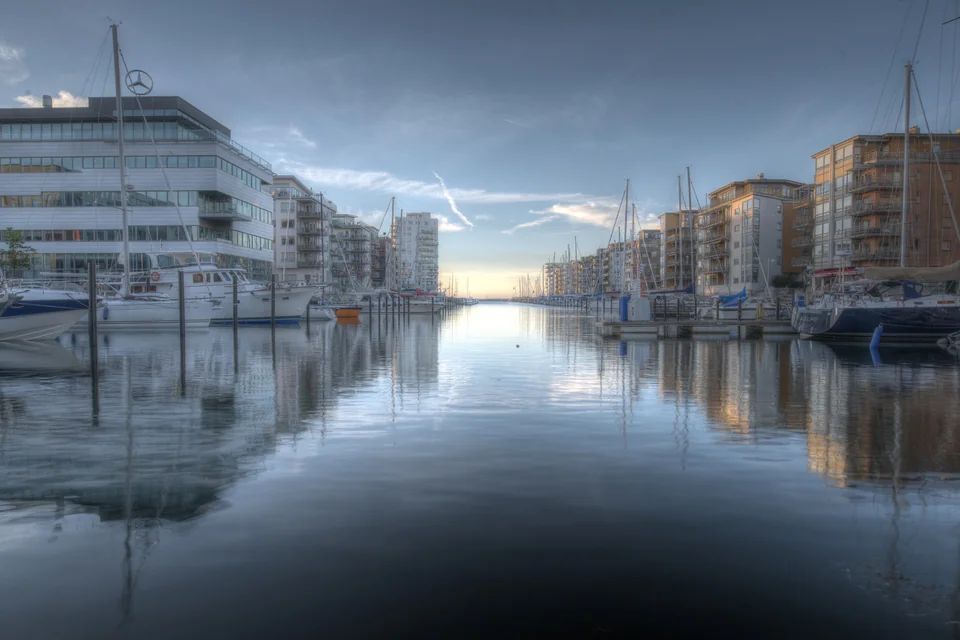 Modern buildings and sailing boats reflected in the Dockan marina, Malmö