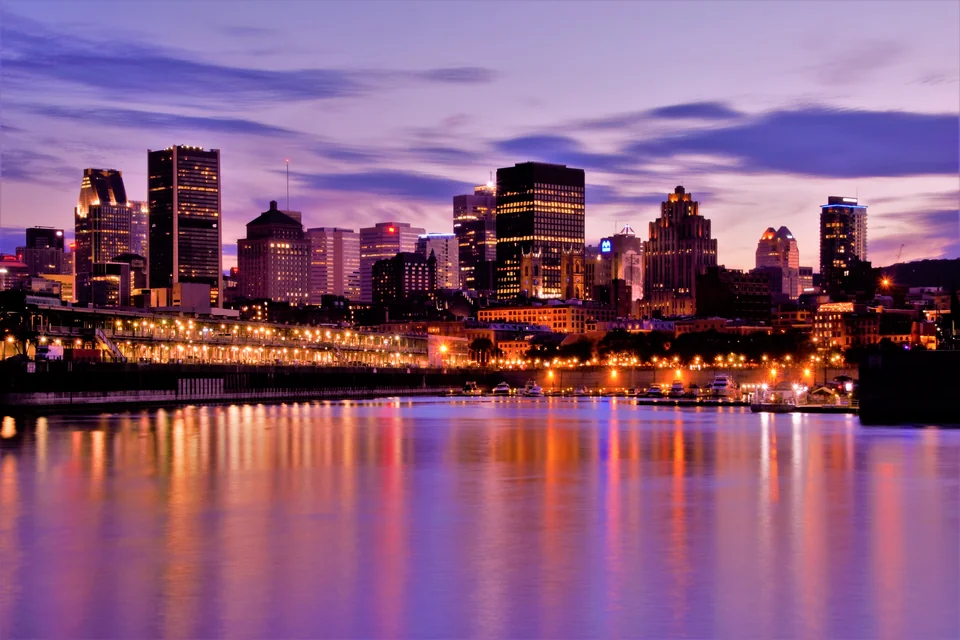 Downtown Montreal lights reflected in the river at dusk