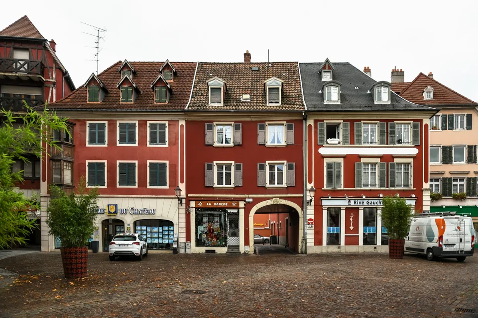 Red-fronted historic houses on a cobbled square in Mulhouse