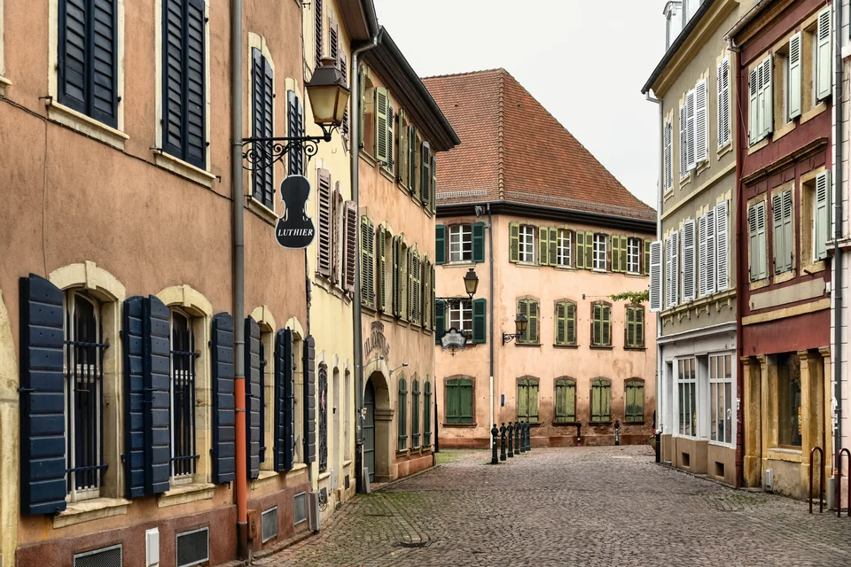 A cobbled street between colourful historic houses in Mulhouse old town