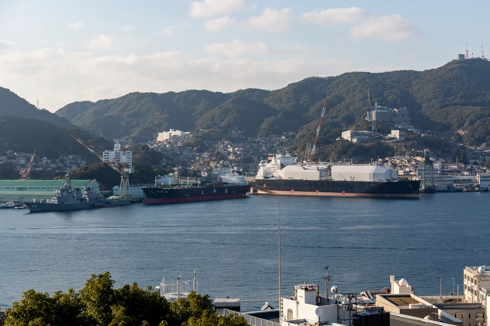 Nagasaki harbour, ships at the quays and green mountains behind