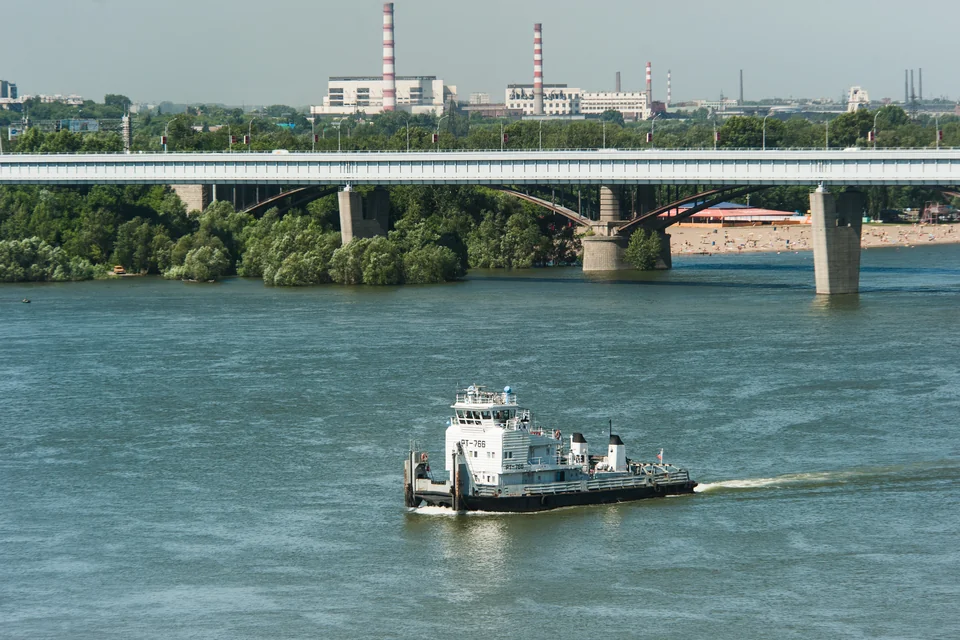 A tugboat on the Ob River with a bridge behind in Novosibirsk