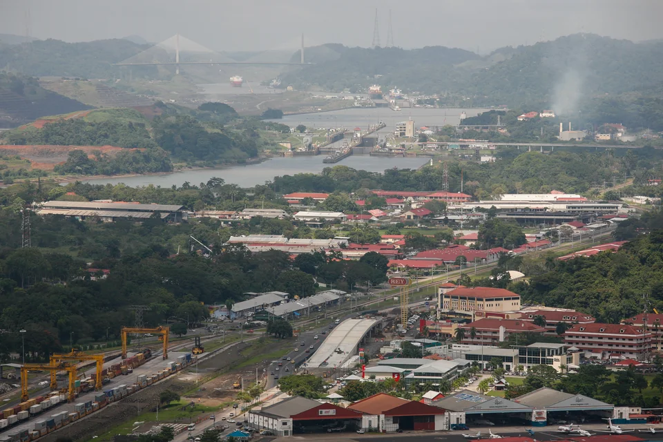 The Panama Canal locks, green hills and a distant bridge near Panama City