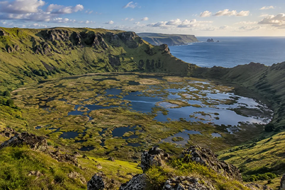 The reed-filled Rano Kau crater lake on Easter Island with the Pacific behind