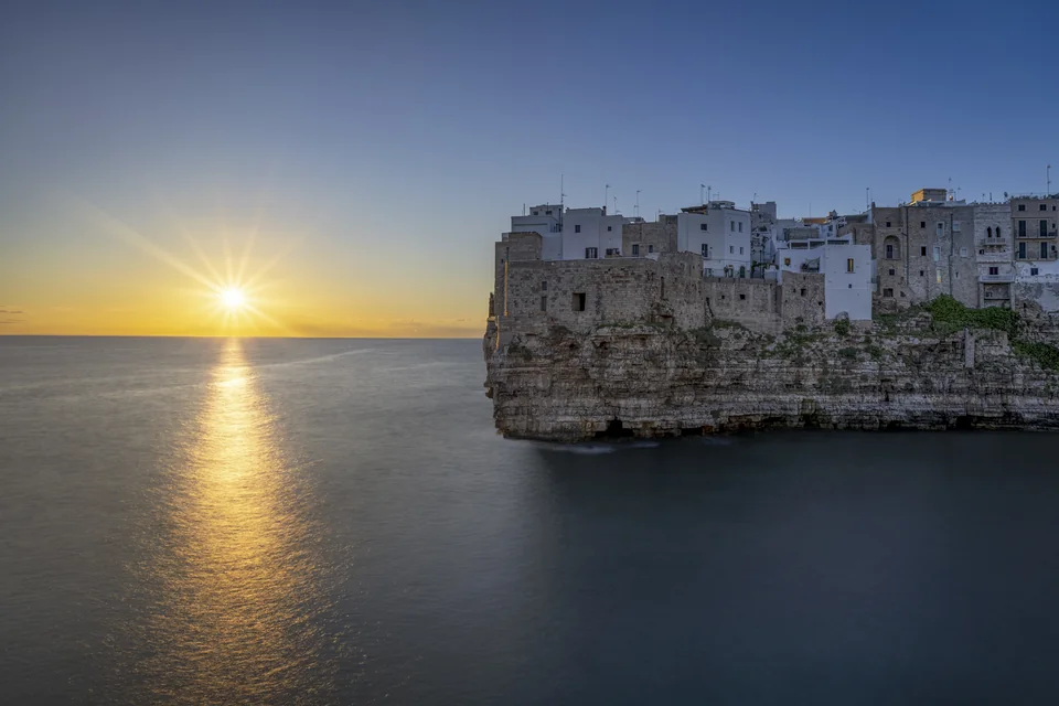 The old town of Polignano a Mare on its sea cliff at sunrise