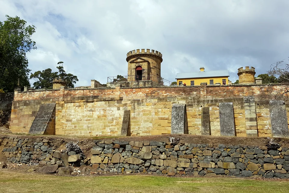 The turreted sandstone guard barracks and stone retaining wall at Port Arthur