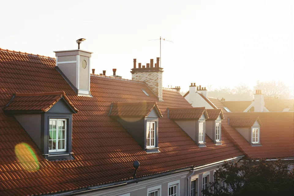 Red tiled roofs and chimneys seen from above in the winter sun in Prague
