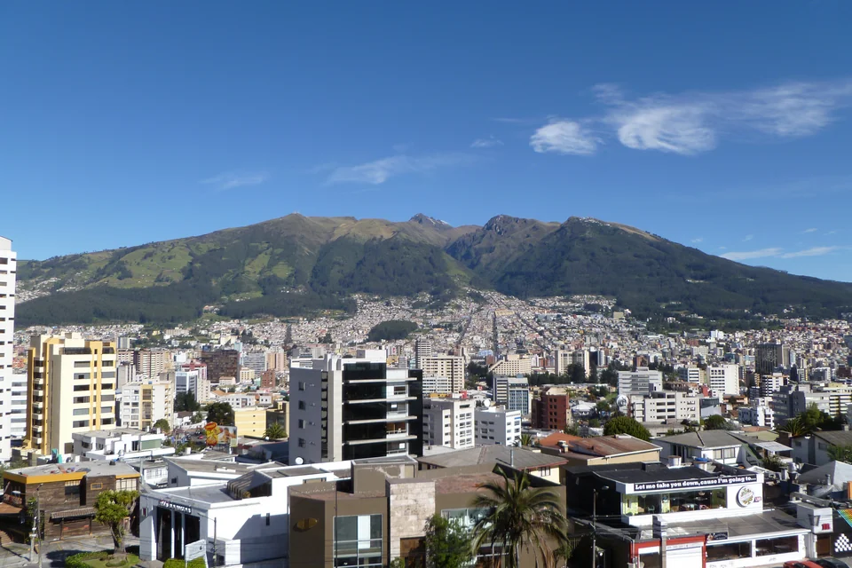 Quito spreading across its valley with the green Pichincha volcano behind