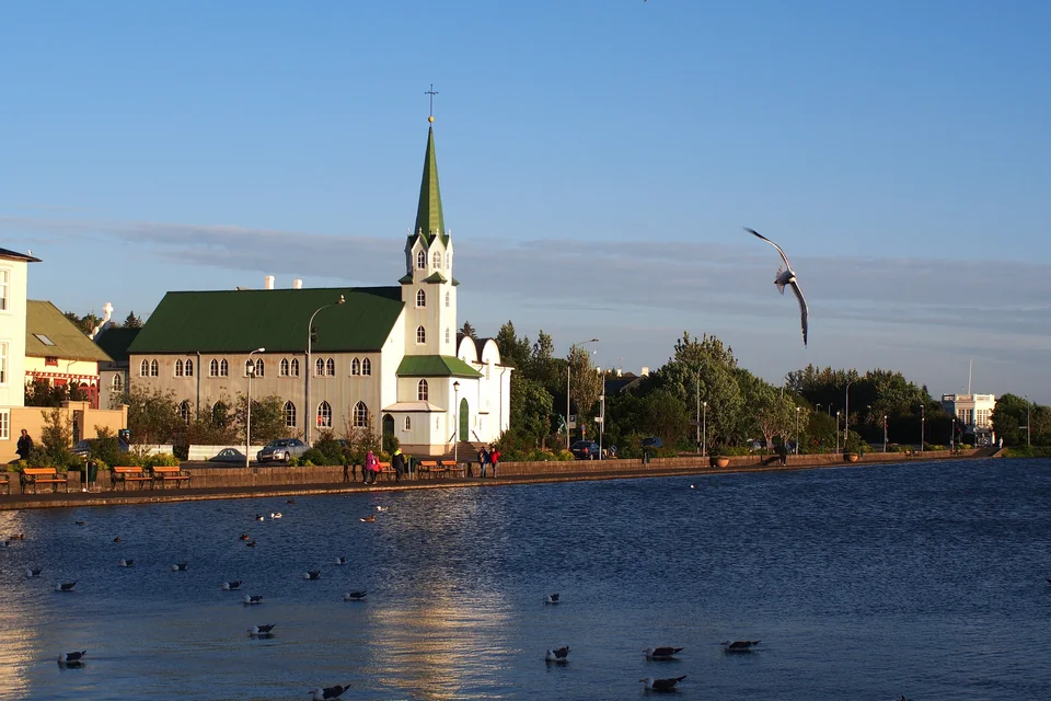 The white Free Church with its green roof on the shore of Lake Tjörnin, Reykjavik