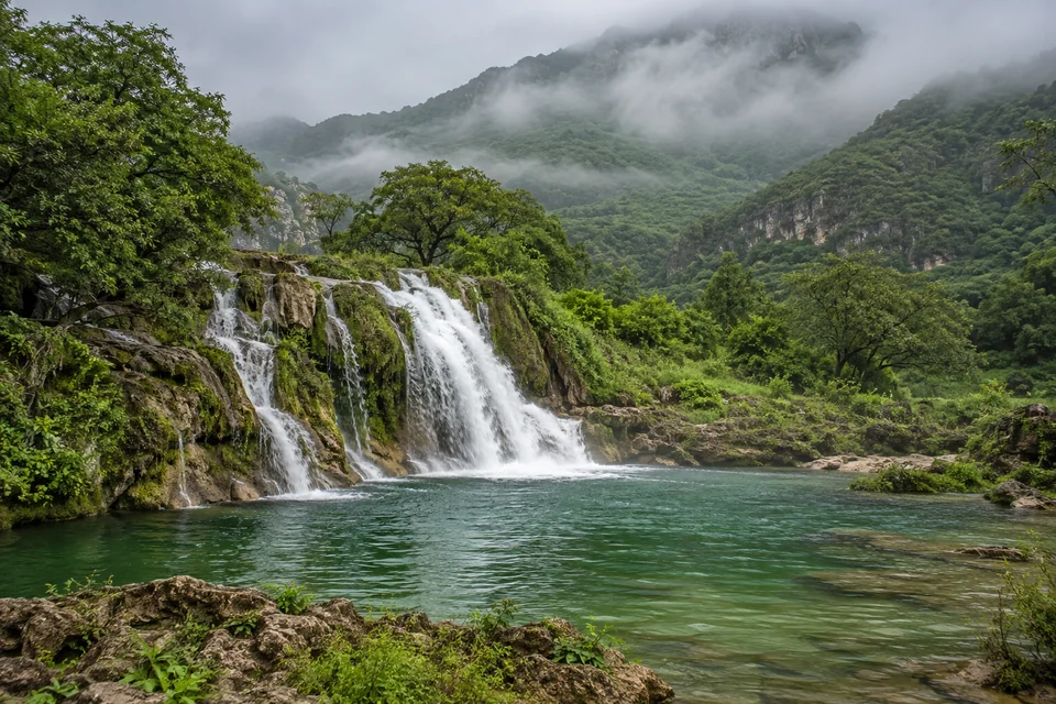 The Wadi Darbat waterfall in Salalah's green valley during the monsoon season