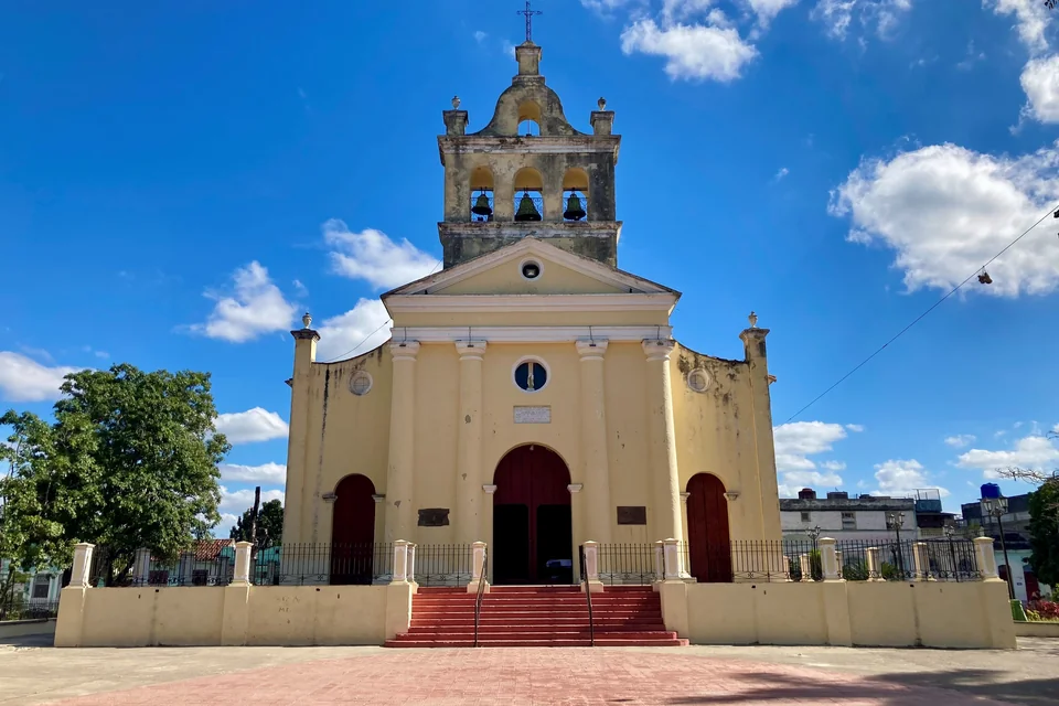The yellow bell-towered Carmen Church and its square in Santa Clara
