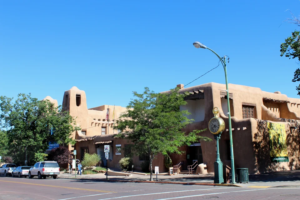 Historic adobe-style buildings on a tree-lined corner in Santa Fe