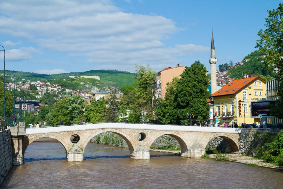 The stone Latin Bridge over the Miljacka River in Sarajevo, with a minaret behind