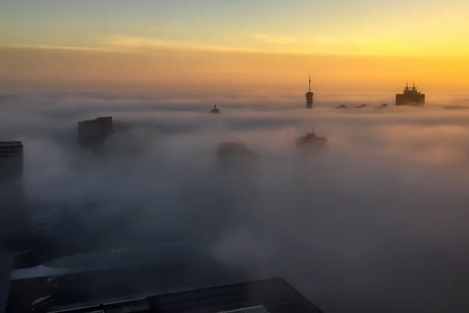 Towers rising above the fog at sunrise in The Hague