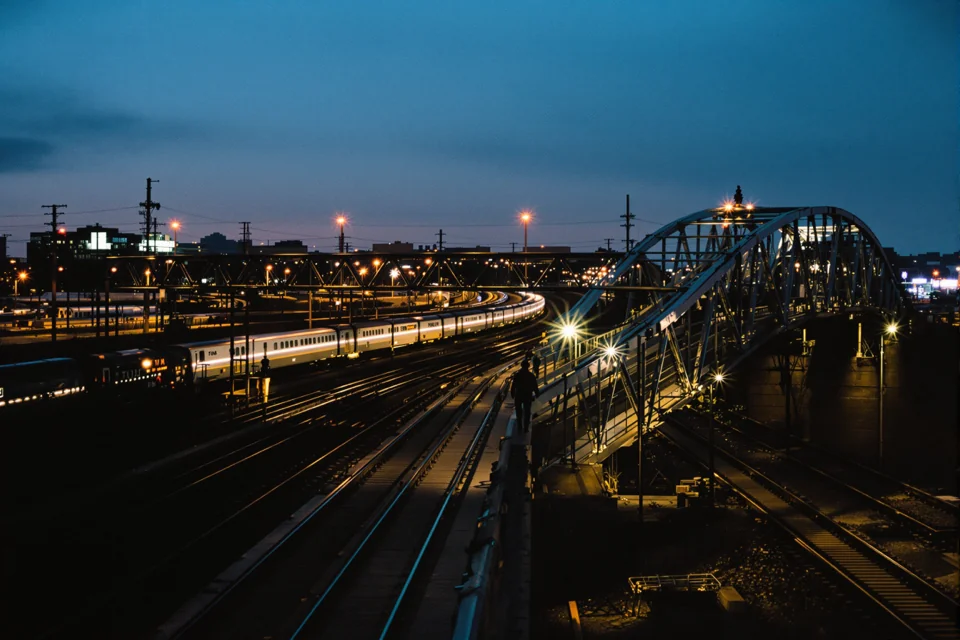 Train tracks lit by evening lights seen from a footbridge in Tokyo