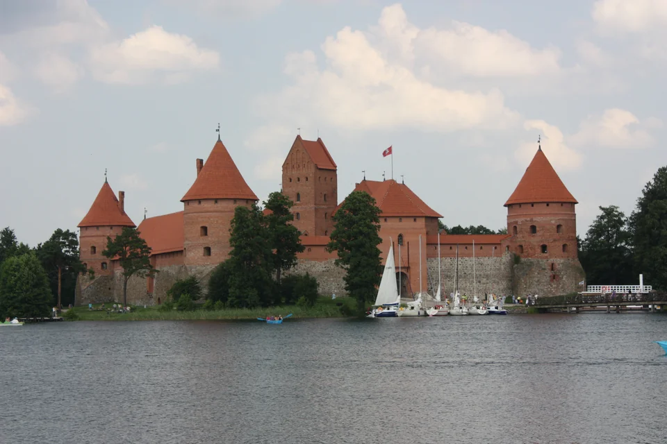 Trakai Island Castle with sailing boats moored on the lakeshore