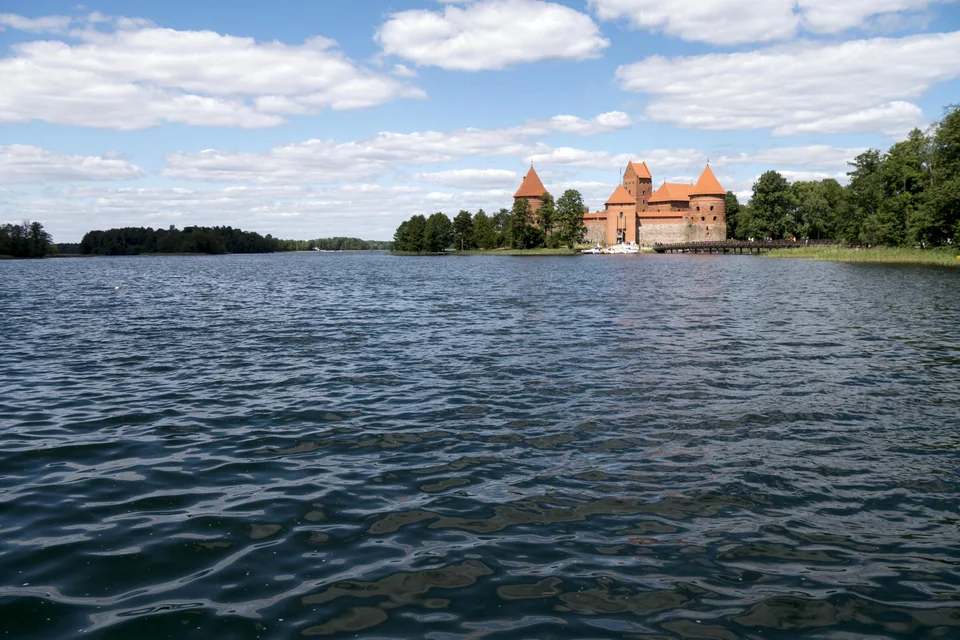 The wide Lake Galvė with the island castle among forests in the distance, Trakai