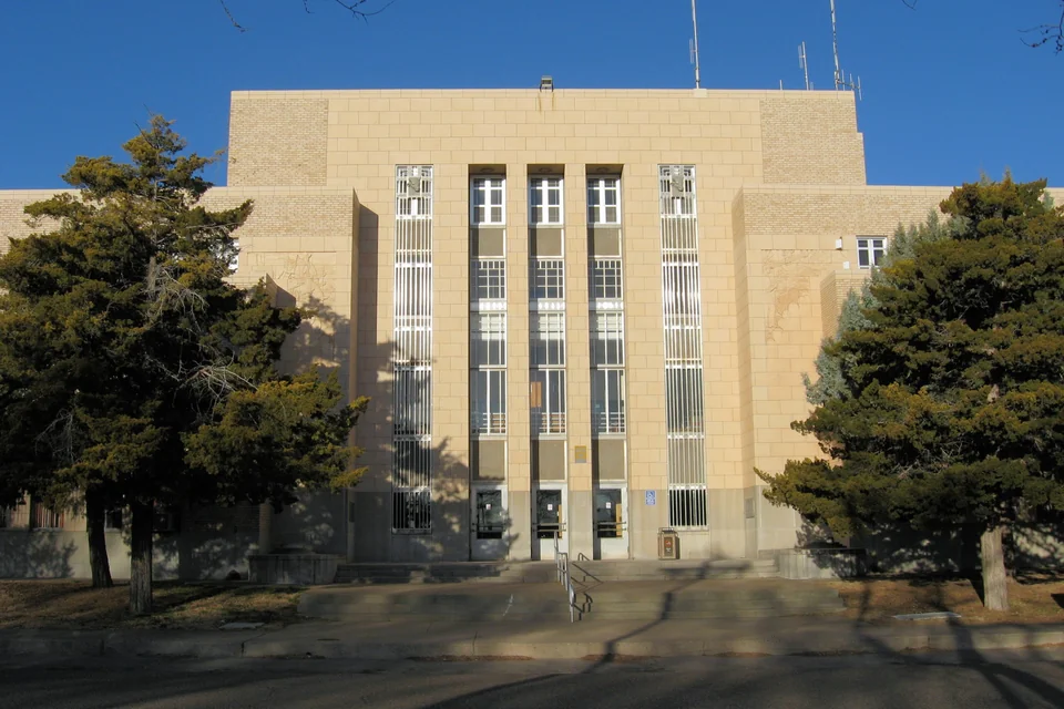 The art deco Quay County Courthouse and pine trees in Tucumcari